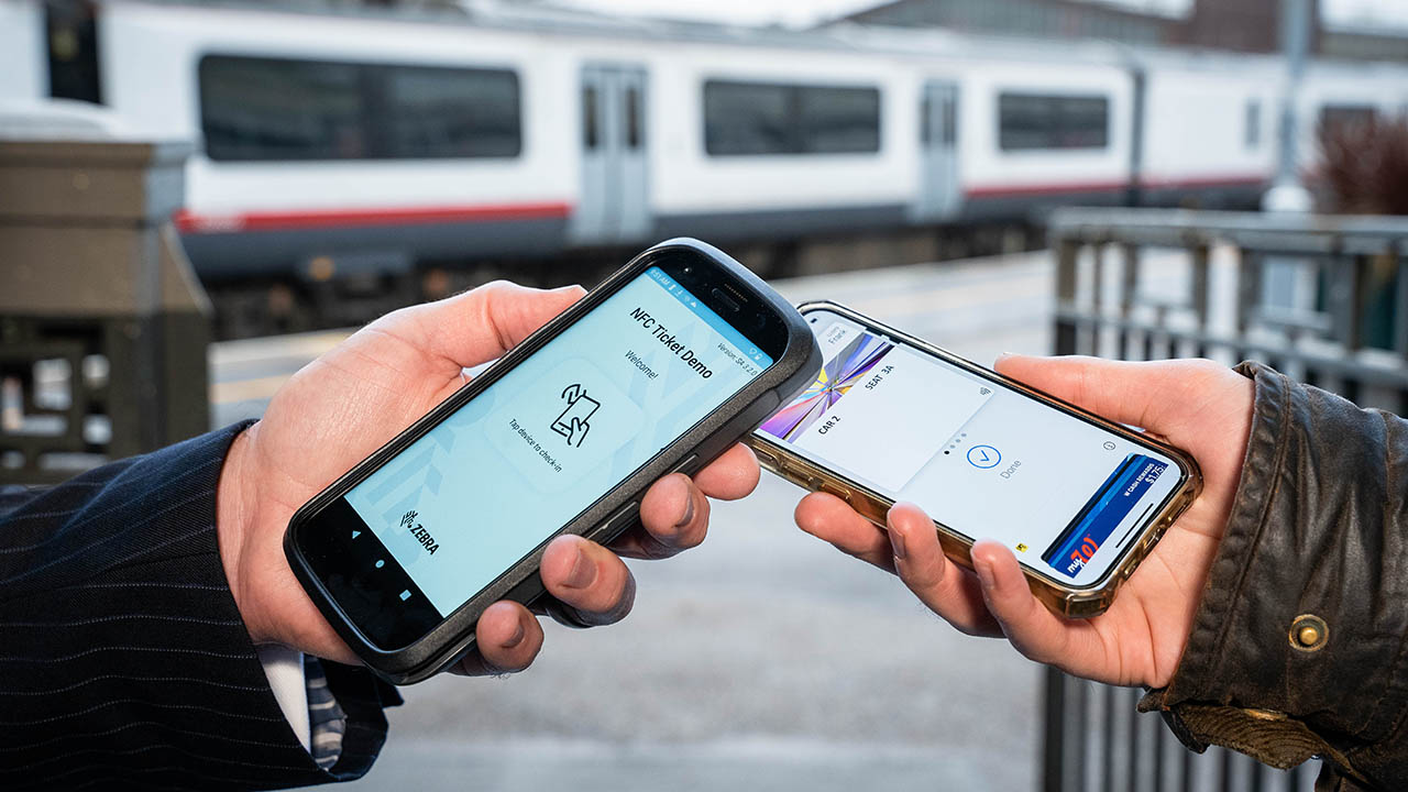 A rail service employee checks a passenger's ticket using Apple Vas digital ticket validation technology on a Zebra mobile computer 