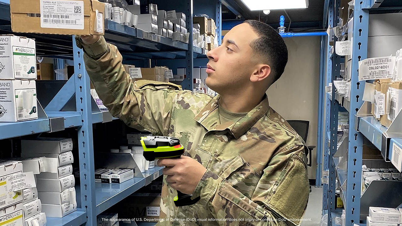 A U.S. military member uses a Zebra barcode scanner in a government warehouse