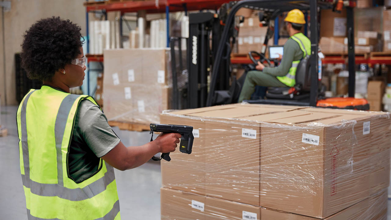 Government warehouse workers use RFID readers and tablets to count and move inventory.