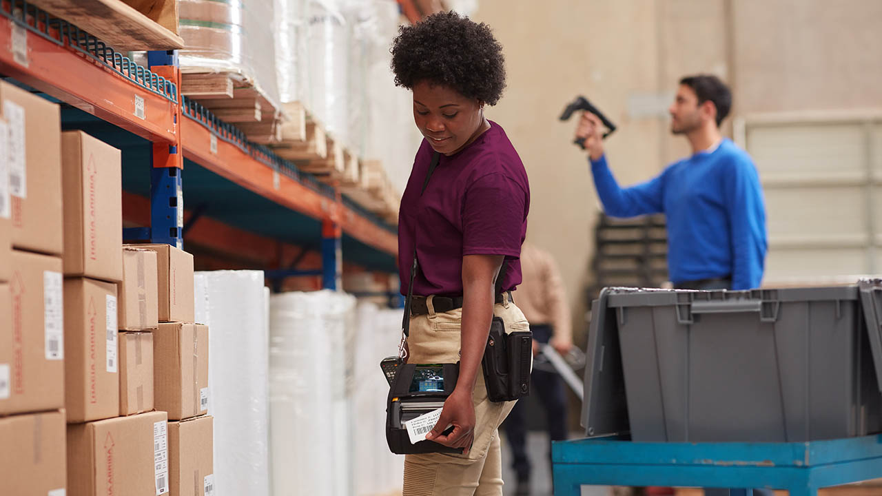 A warehouse worker pulls a label off a Zebra ZQ630 mobile printer
