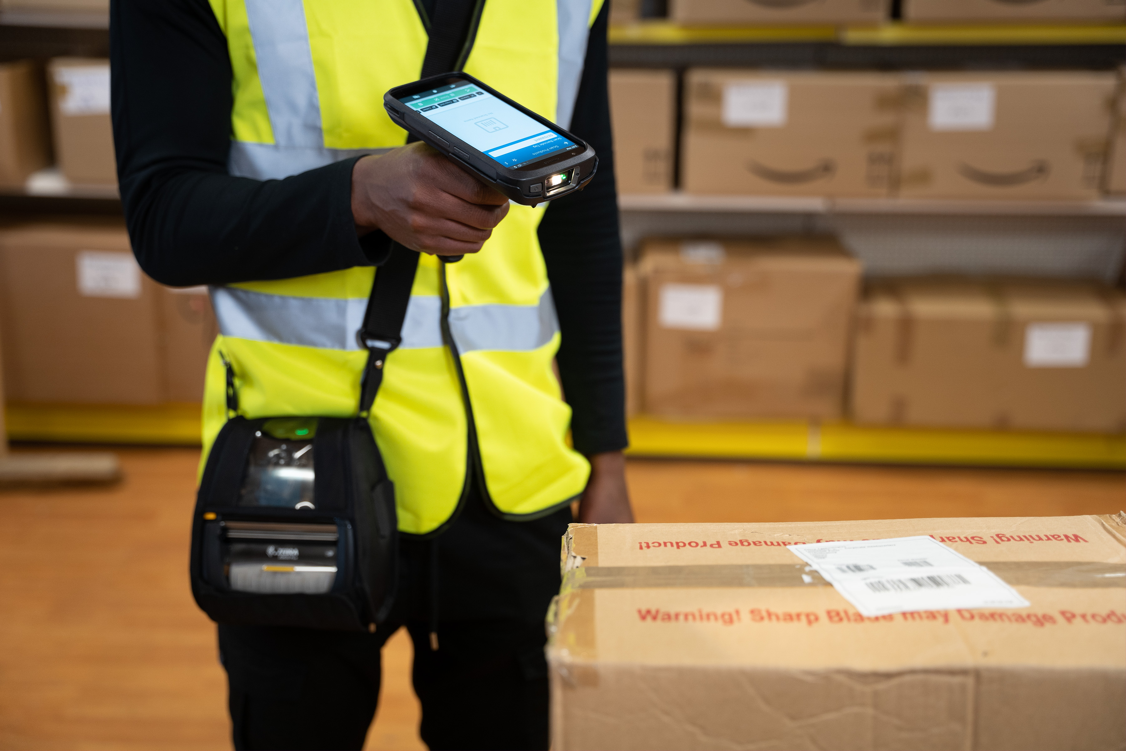 Photography of a warehouse worker using a TC22 to scan a barcode.
