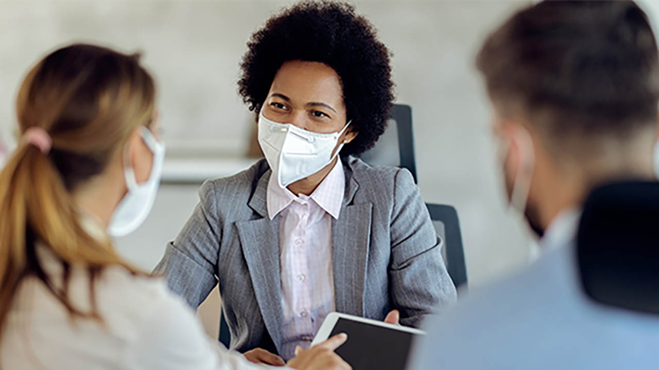 A financial advisor meets with clients at a bank during a scheduled appointment time.