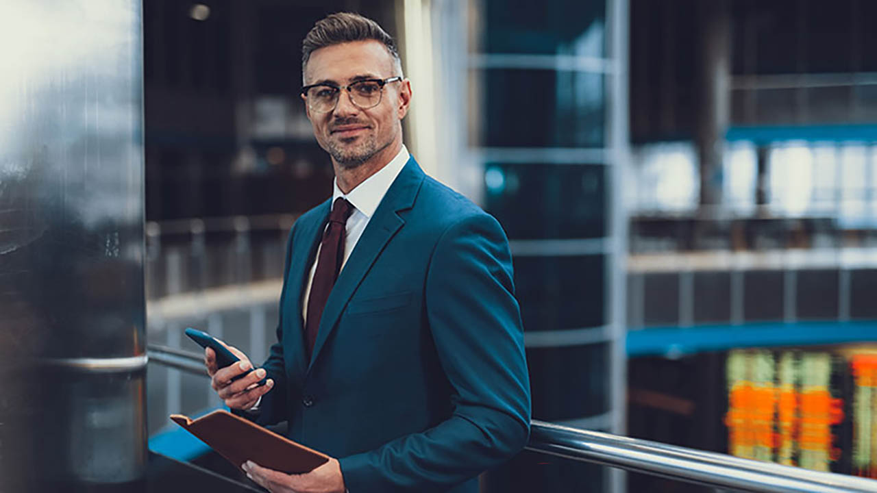 A man stands at bank smiling