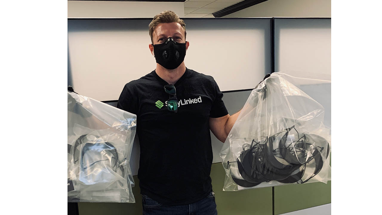 Justin Griffith, CTO of StayLinked, holds bags of 3D printed face shields