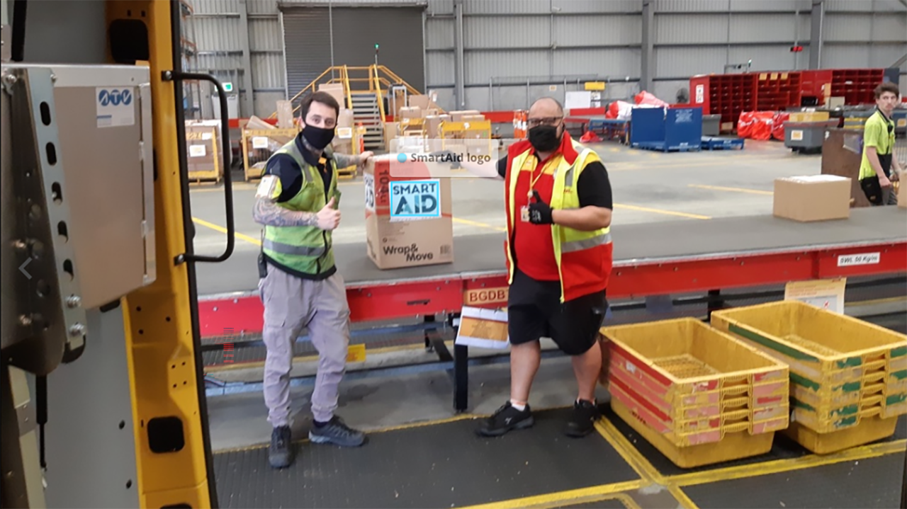 SmartAid warehouse workers give a thumbs up