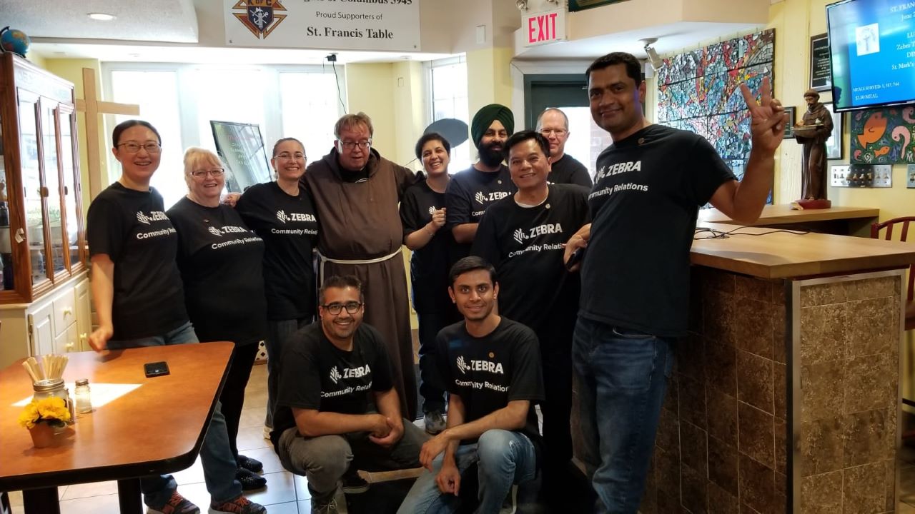 Zebra employees take a group photo with Brother John of the St. Francis Table soup kitchen in Mississauga after volunteering for the day. From left, Leah Li, Sharon Owen, Ozlem Seri, Brother John from St. Francis Table, Persis Daver, Gurjit Matharoo, Dave Lawson, Lawrence Lam, Dharmajit Solanki, Ali Saifuddin & Kushal Sakhia.