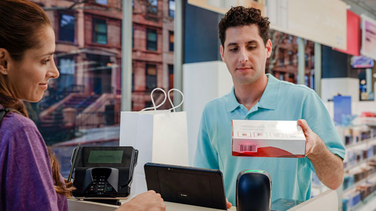 A retail store associate helps a customer check out.