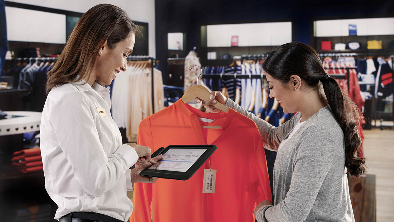 The Zebra ET51 Android rugged tablet with integrated scanner is used by a retail store associate to help checkout a customer via mobile point of sale