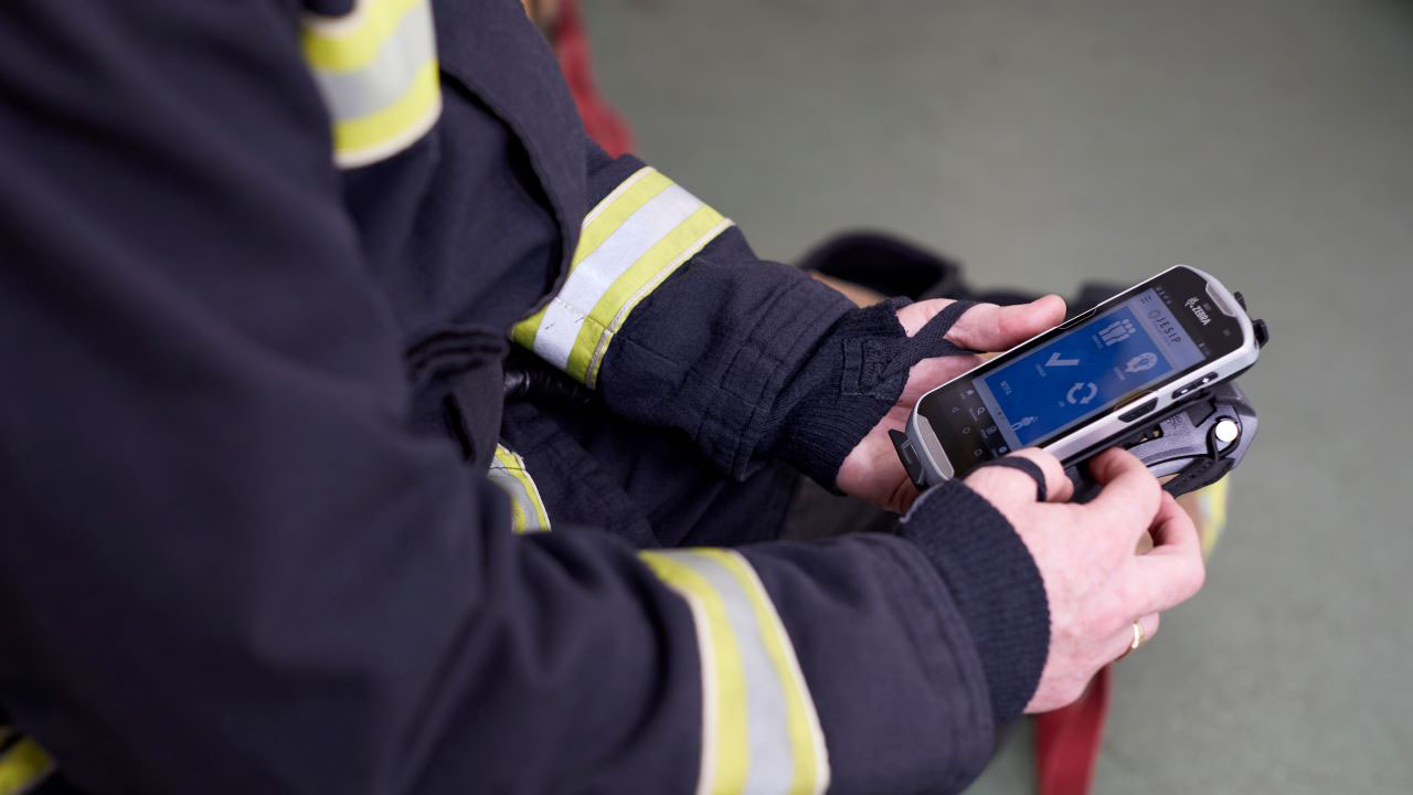 A firefighter looks at the screen of a Zebra TC52 mobile computer.