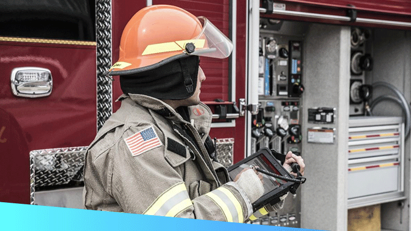 Firefighter using a rugged tablet with a hard top handle to document information on scene