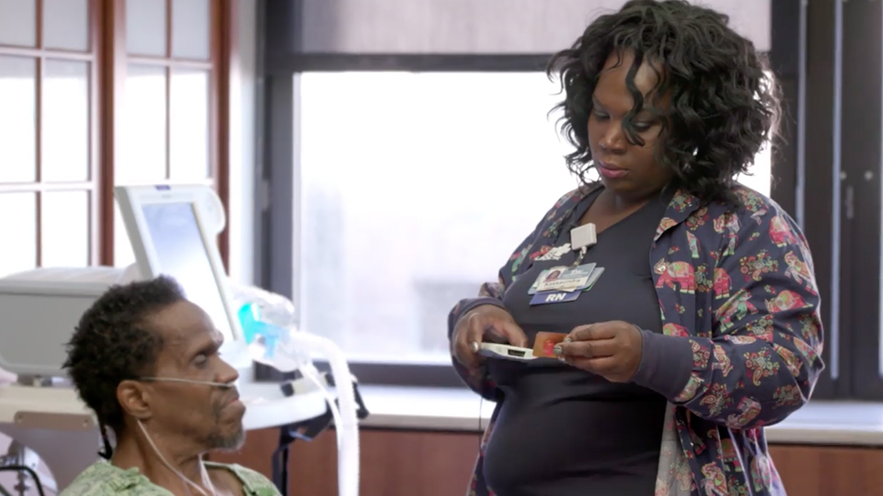 Kassaundra McKnight-Young, BSN, RN, uses a Zebra mobile computer to provide care at the patient's bedside.