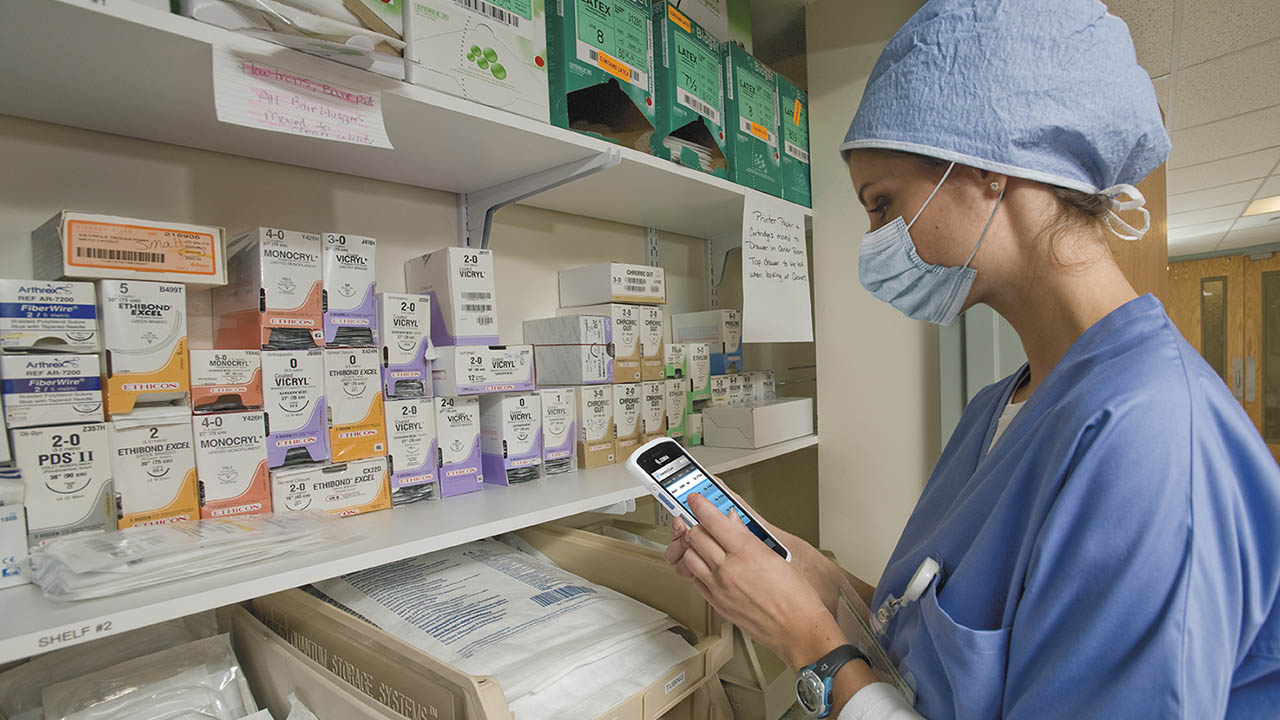 A healthcare provider uses a mobile computer to locate supplies in the stockroom