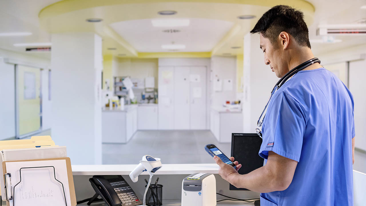 A nurse talks to a colleague using Workforce Connect on his Zebra TC52ax-HC mobile computer