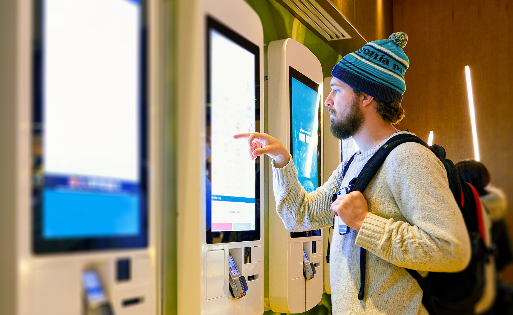 A man uses a touchscreen kiosk to retrieve information