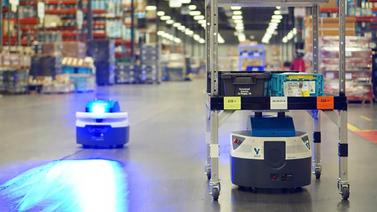Two Fetch robots from Zebra move autonomously in a warehouse, one carrying bins