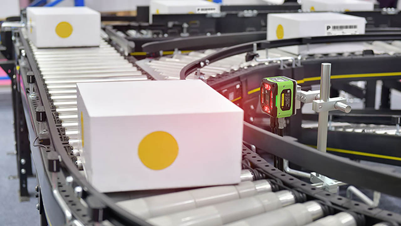 Boxes are read by a Zebra machine vision camera as they move down a conveyor belt.