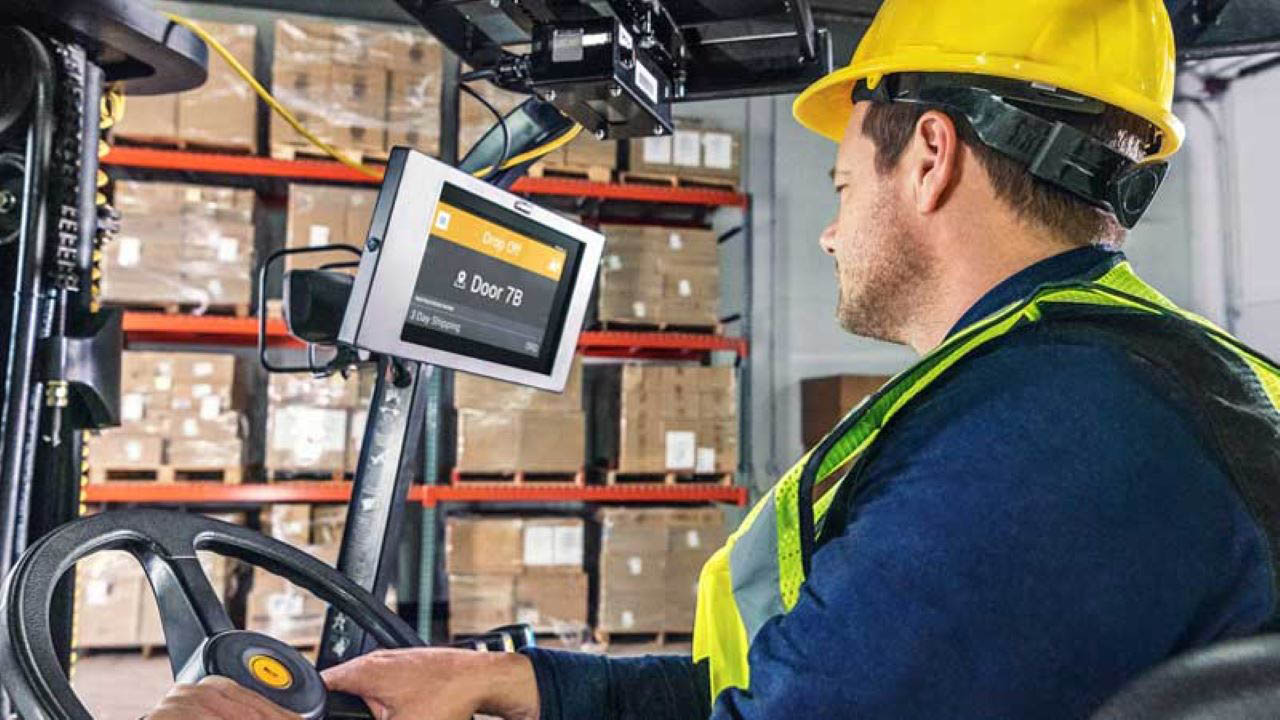 A forklift operator looks at a fixed computer screen