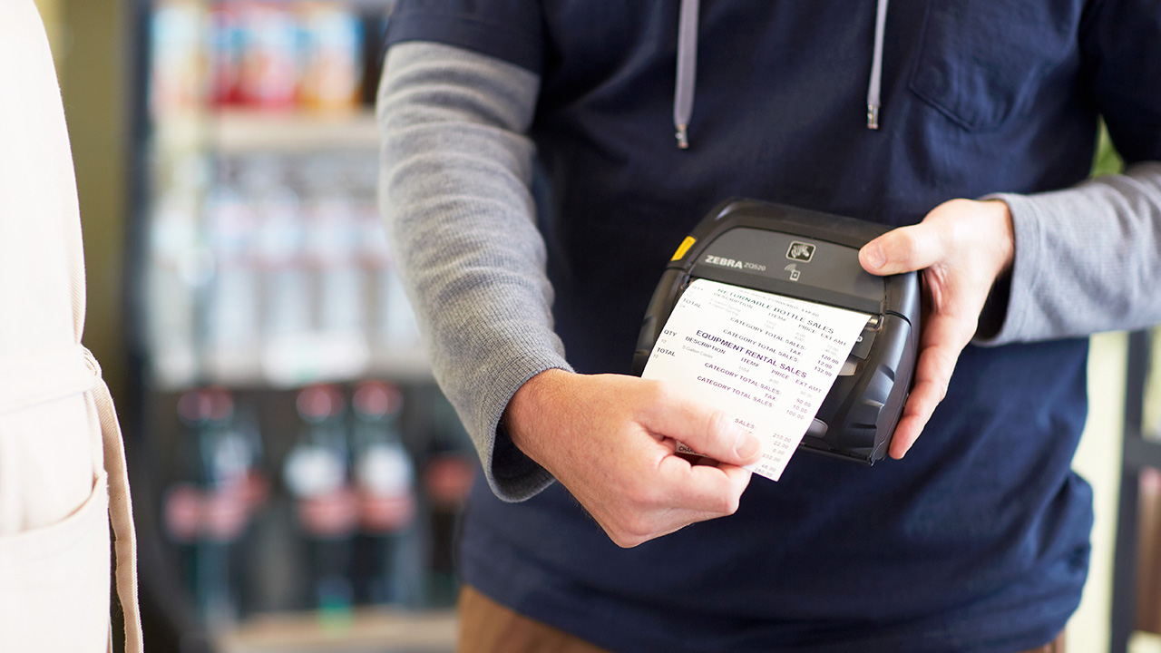 A delivery driver use a mobile printer to generate a receipt for a customer. 