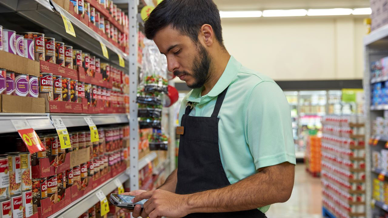 A retail store associate uses a handheld mobile computer to document inventory counts