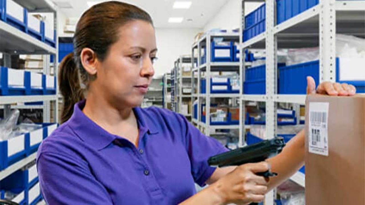 A retail store associate processes an online return in the store room