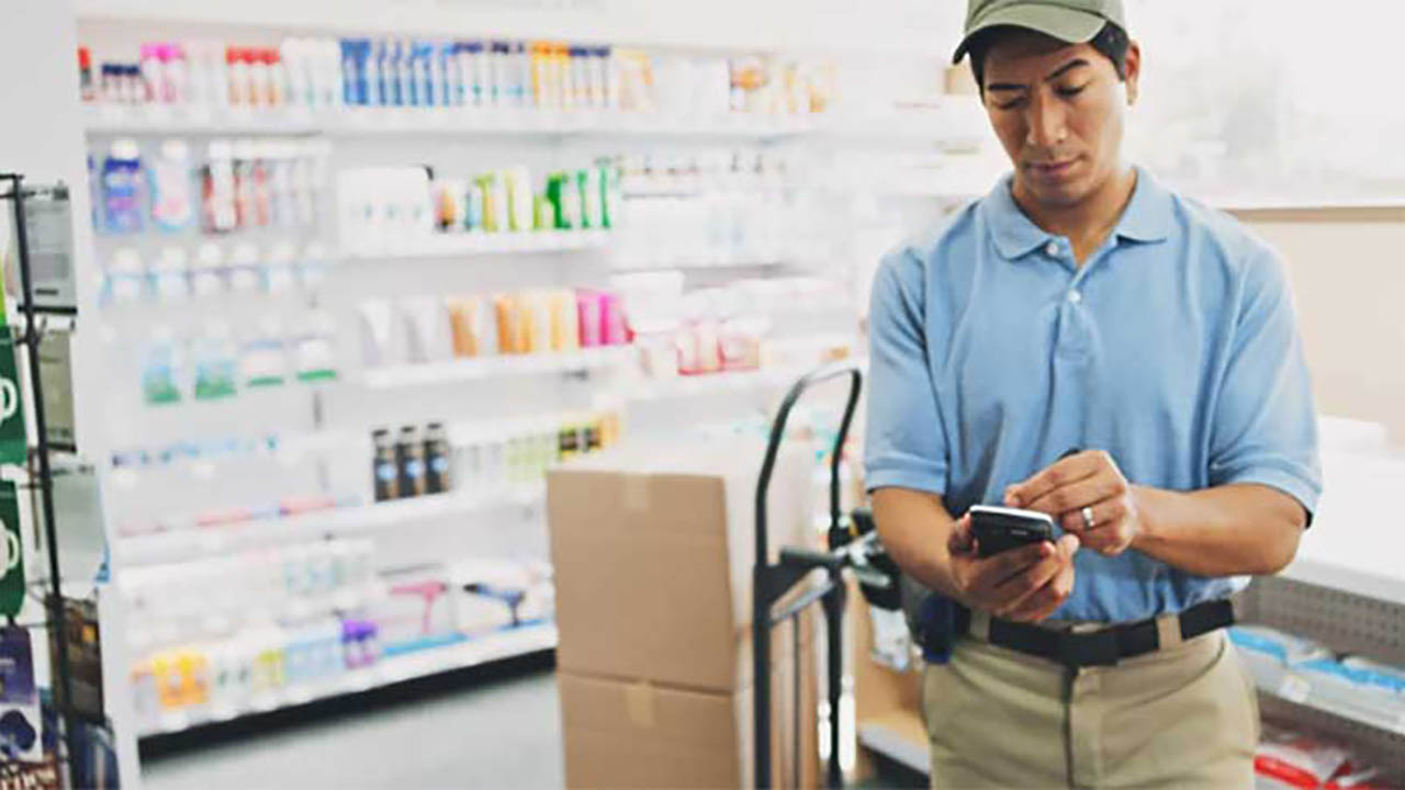 A retail store associate uses a handheld mobile computer to review the next task on his to-do list.