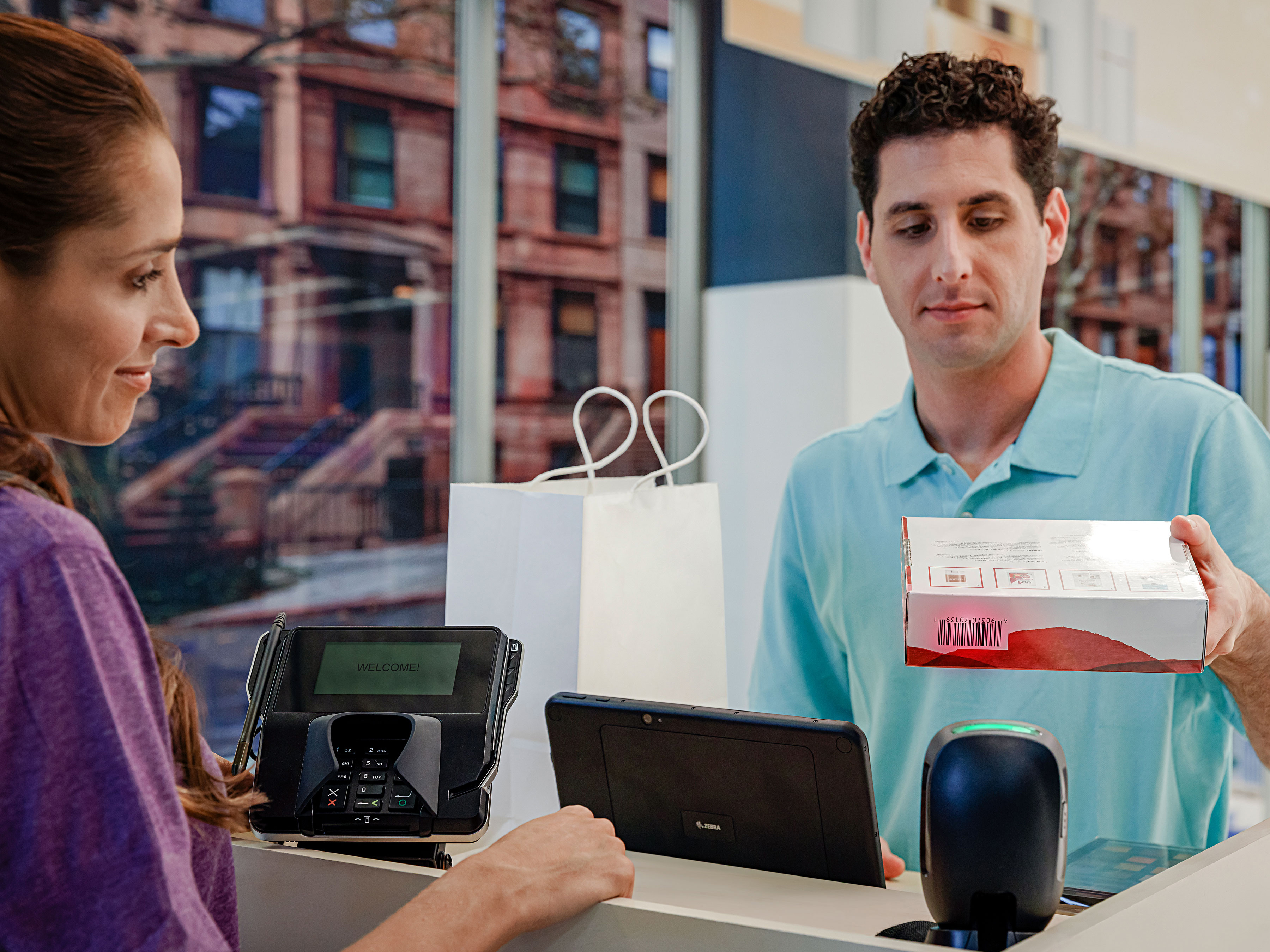 A drug store employee scans the barcode on a customer's item