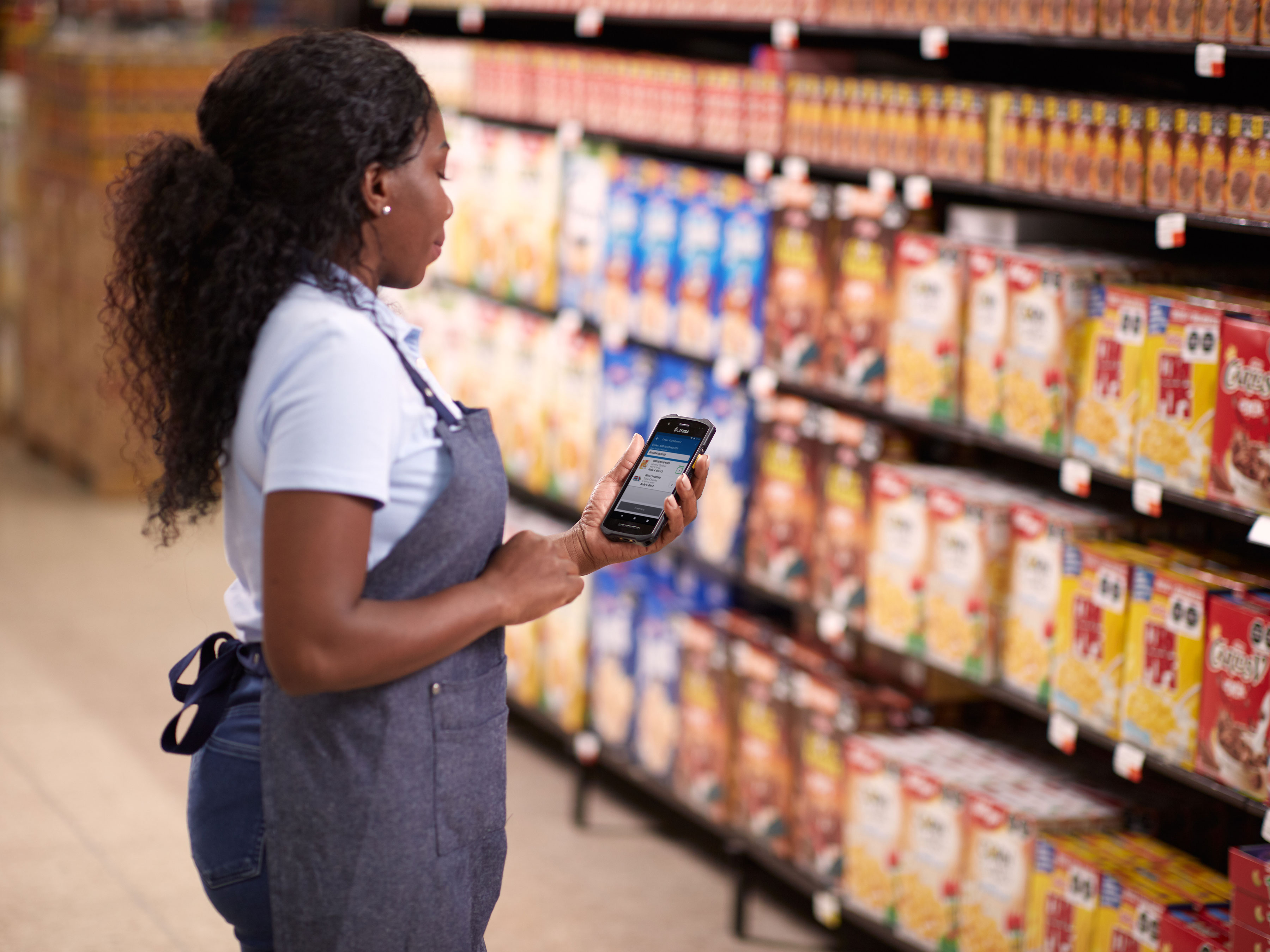 Grocery store associate using the Zebra TC21 handheld mobile computer to check inventory