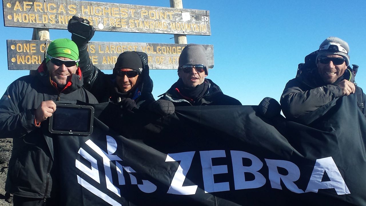 Three Zebra employees and a friend at the top of Mount Kilimanjaro.