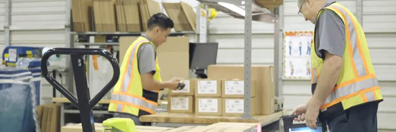 Two Zebra employees use Zebra technology in a warehouse as part of the Zebra4Zebra program 