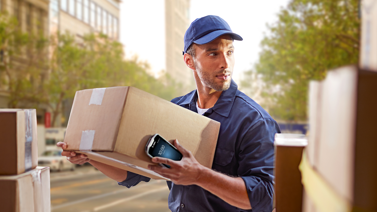 A deliver driver prepares to load a returned package onto his truck to take back to the warehouse.