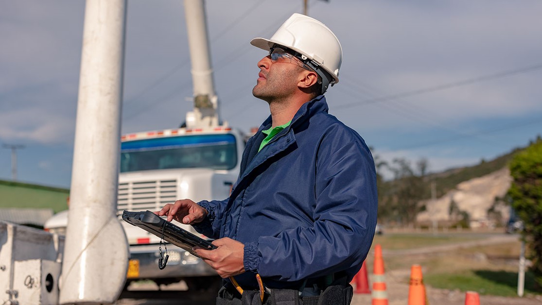 A utility worker uses a rugged tablet to locate an asset in the field