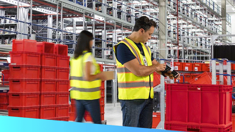 A male worker and female worker using mobile technologies to complete tasks in a future-ready warehouse
