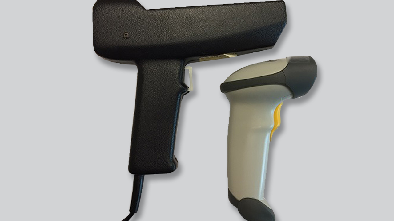Handmade model of symbol's first successful handheld scanner next to a smaller scanner