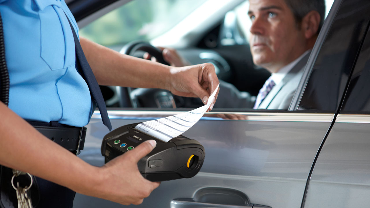 A police officer uses a Zebra printer to generate a traffic ticket