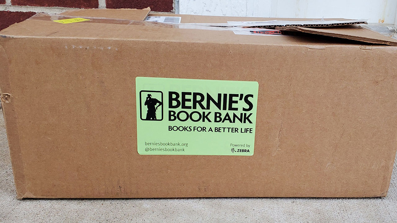 A picture of a Bernie's Book Bank box with a green label printed with a Zebra printer