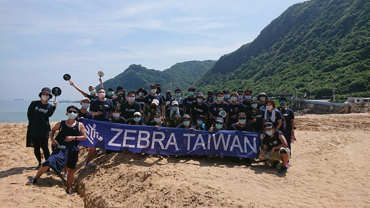 Employees from the Zebra Taiwan office pose for a photo after a recent beach cleanup