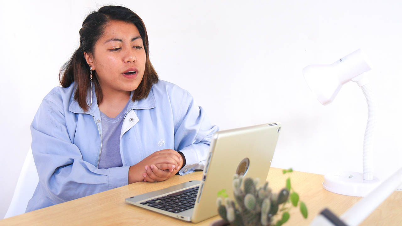 A woman speaks with a healthcare provider via her laptop