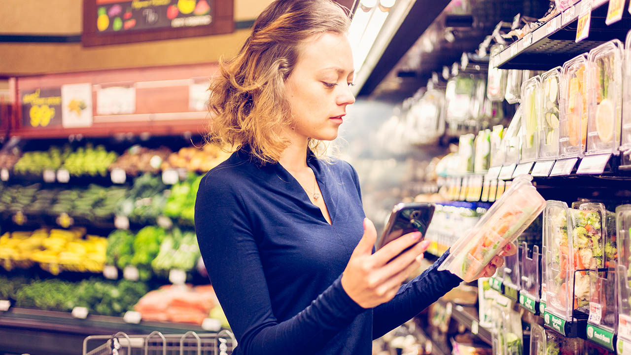 A woman looks at produce at the grocery store