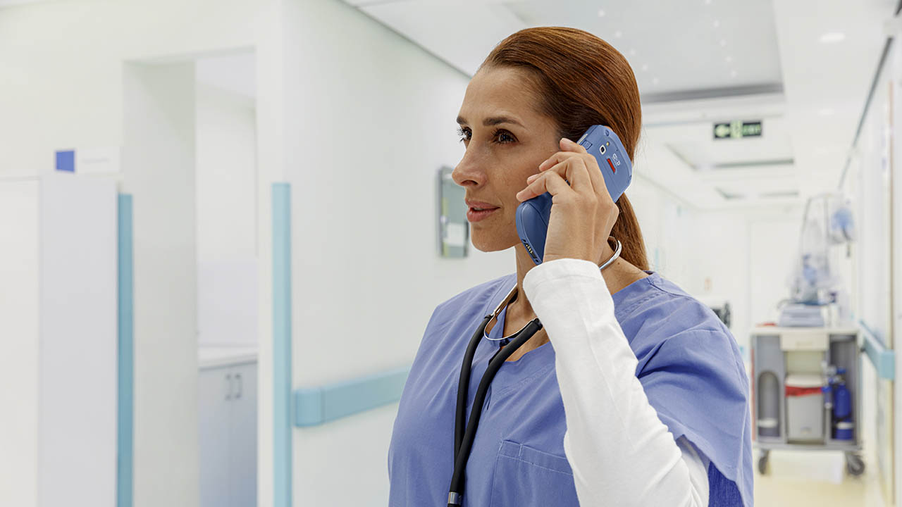 A nurse talks on a Zebra TC52ax-HC clinical smartphone