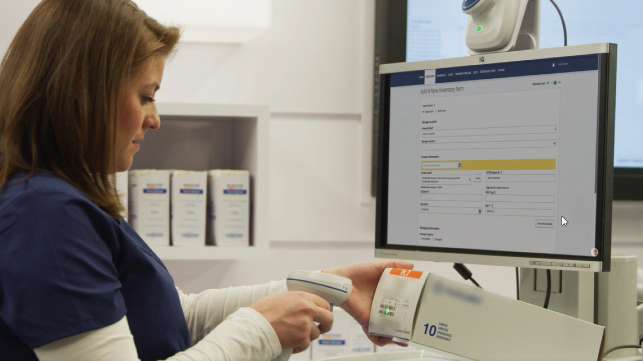 A nurse uses a Zebra barcode scanner to capture UDI data from medical device packaging