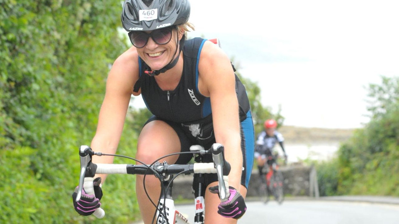 Lorna Hopkin smiles while competing in the biking segment of a recent Ironman race