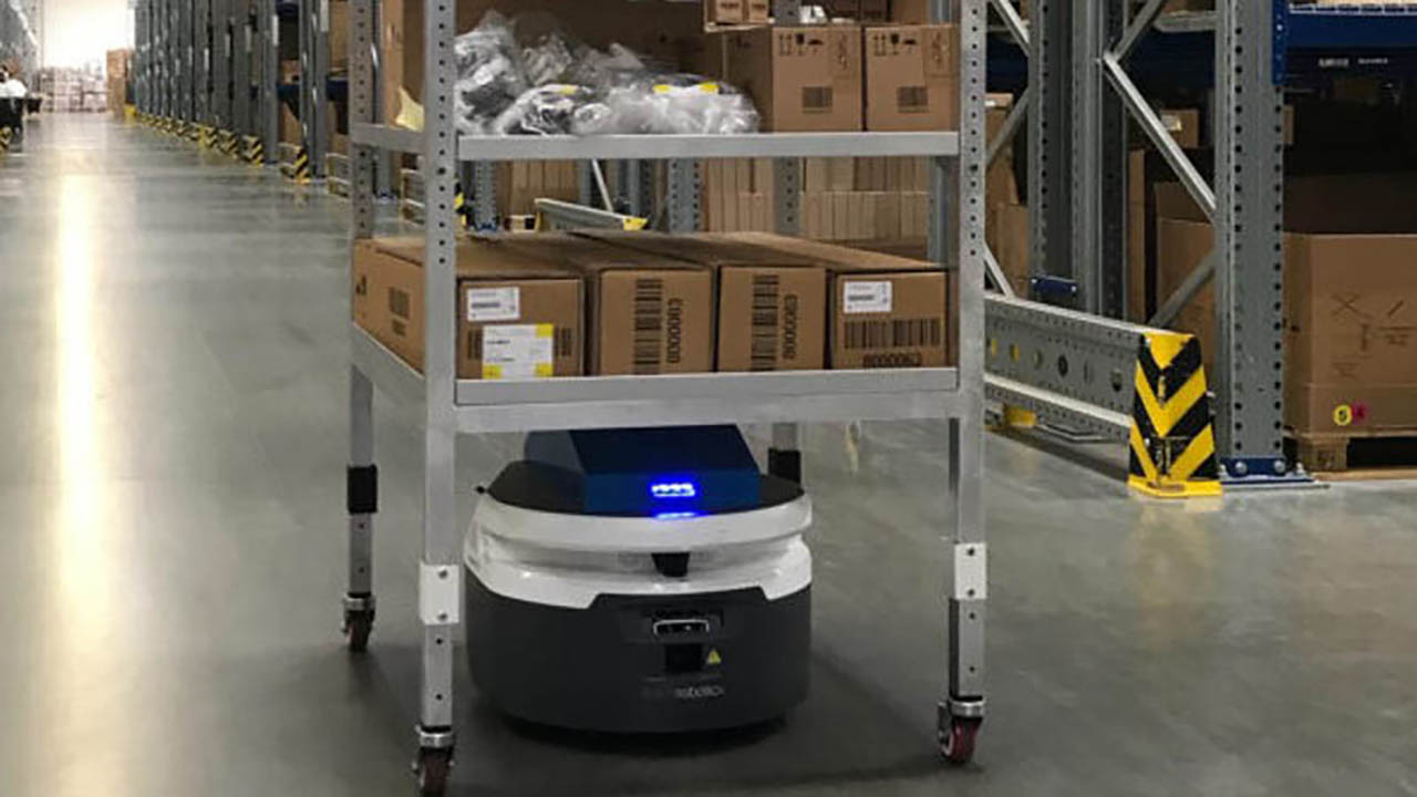 A Fetch AMR transports boxes across a manufacturing facility