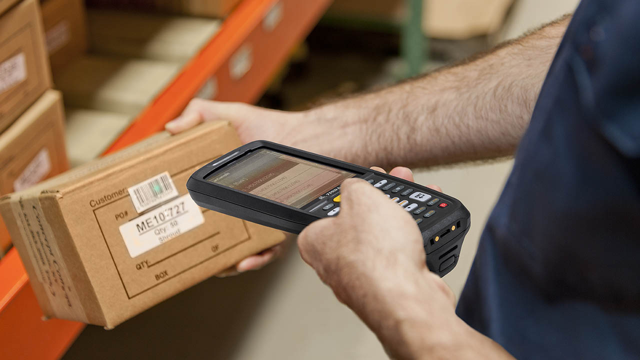 A retail worker uses the MC2700 to scan items in a warehouse