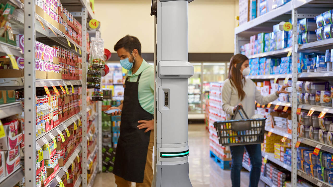 The Zebra EMA 50 enterprise mobile automation system navigates around two grocery store associates and a shopper in an aisle