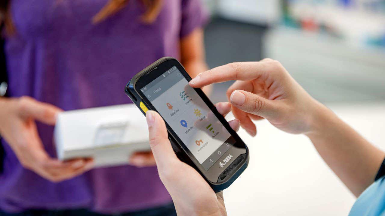 A retail store associate uses a Zebra TC20 handheld touch mobile computer to help a customer from a safe distance