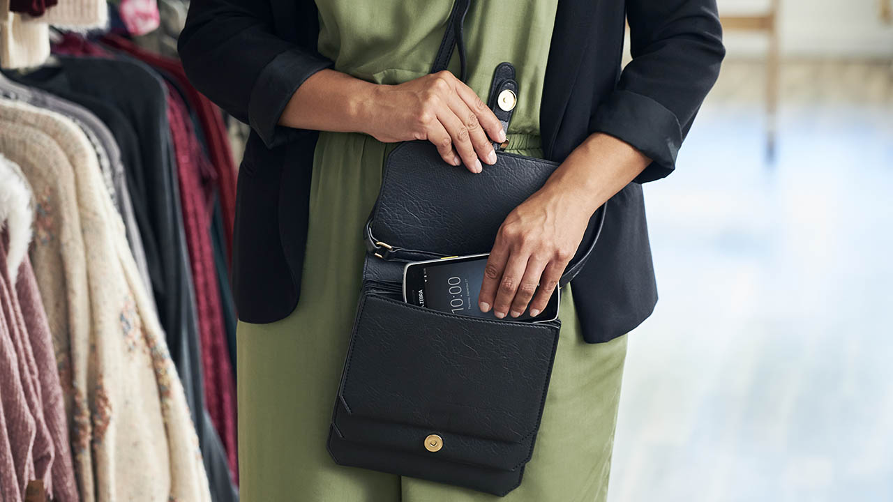 A woman puts a Zebra EC50 handheld computer in her purse