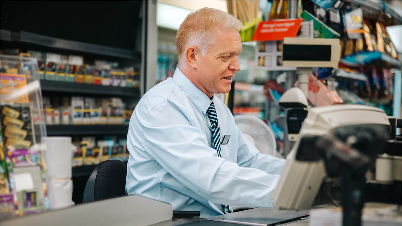 A retail store manager works a point of sale desk