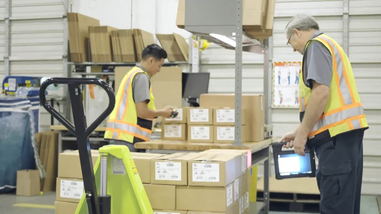 Two Zebra employees use Zebra technology in a warehouse as part of the Zebra4Zebra program 