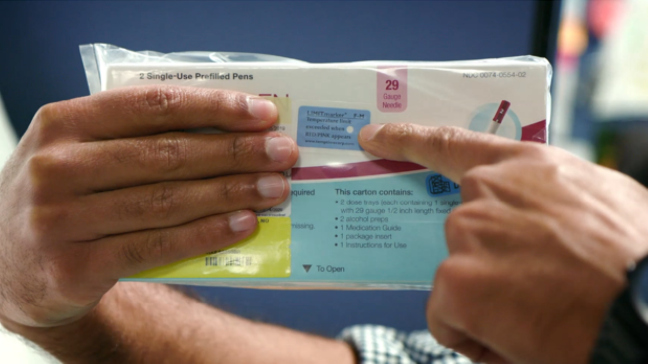 Someone points to the temperature-sensing label on a biologic shipped from Preveon Specialty Pharmacy