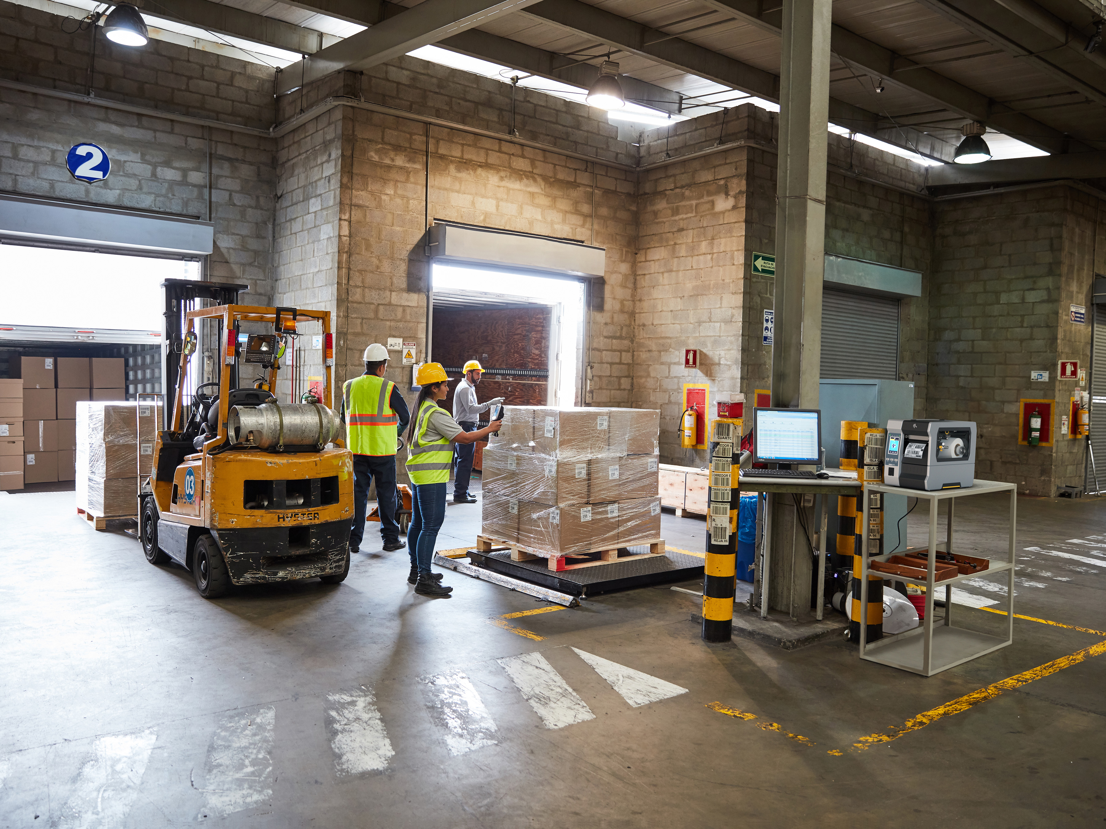 Workers scan products using Zebra devices as they move product at a cross-dock